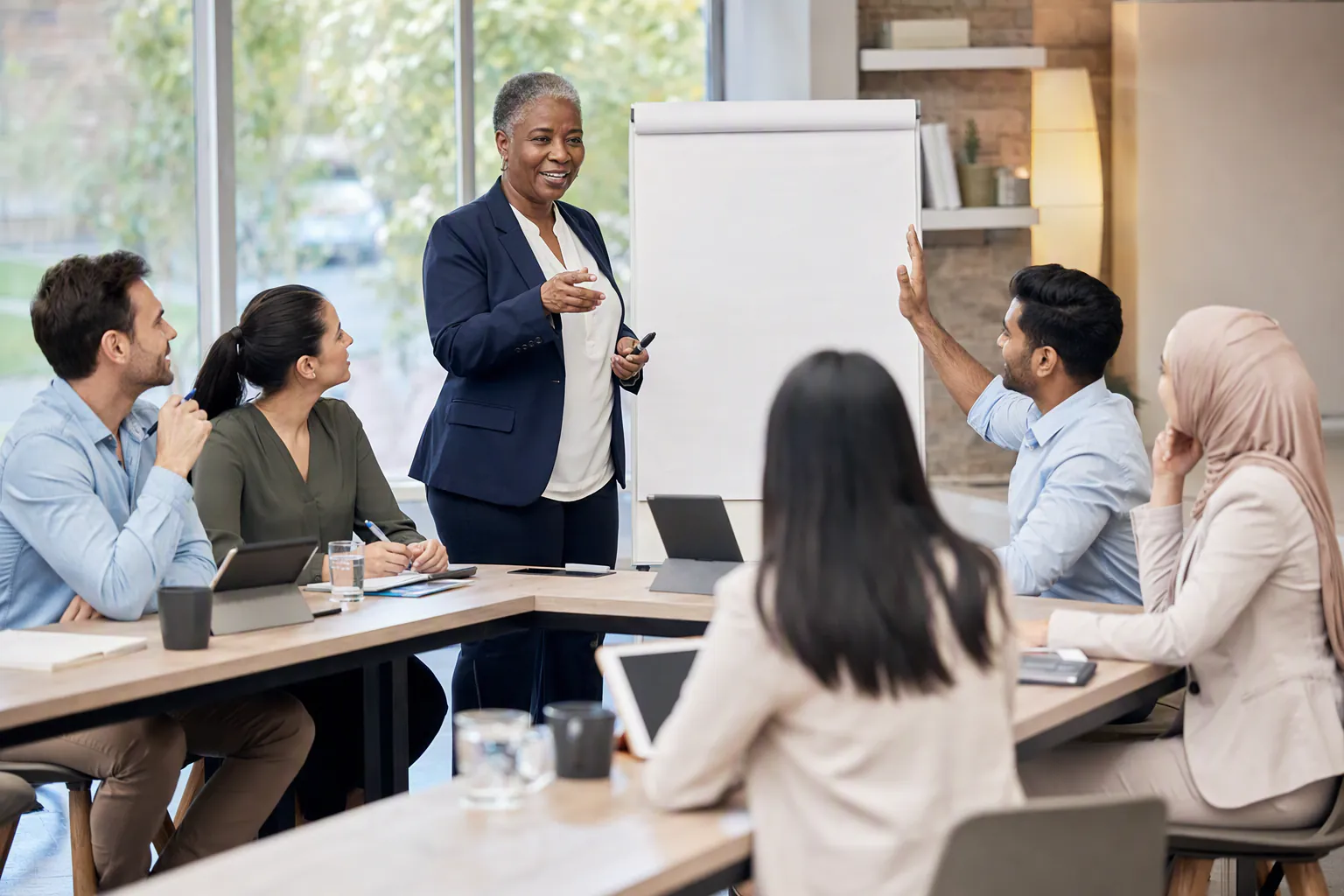 A facilitator leading a diverse sales team through a LongArena simulation workshop